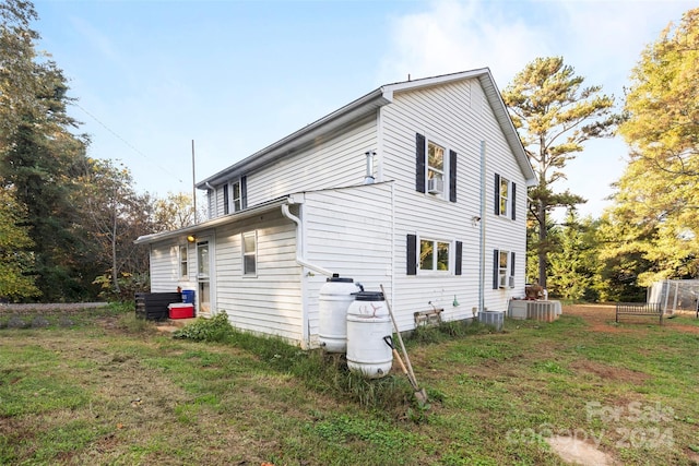 view of property exterior featuring central AC unit and a yard