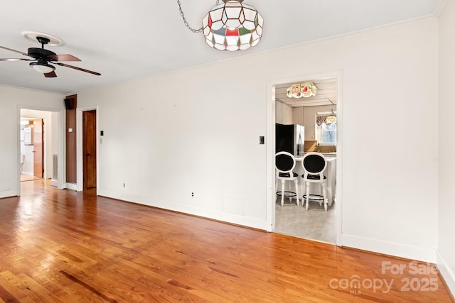 spare room featuring hardwood / wood-style flooring, ceiling fan, and ornamental molding