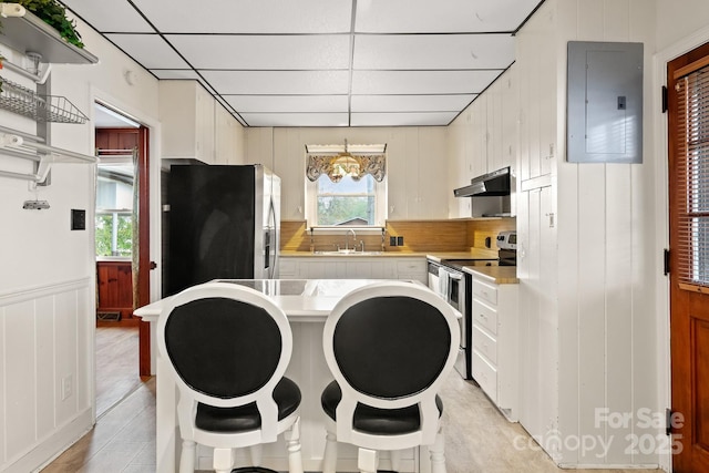 interior space featuring electric panel, sink, stainless steel appliances, and plenty of natural light