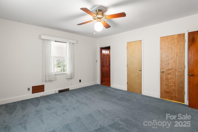 unfurnished bedroom featuring two closets, dark carpet, and ceiling fan