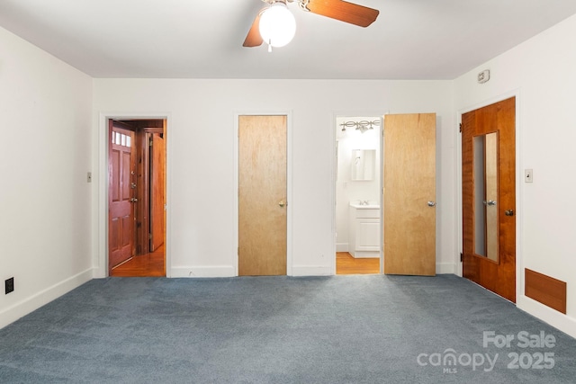 unfurnished bedroom with carpet flooring, ensuite bathroom, and ceiling fan