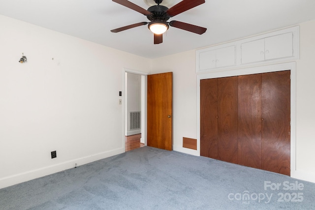 unfurnished bedroom featuring carpet floors, a closet, and ceiling fan