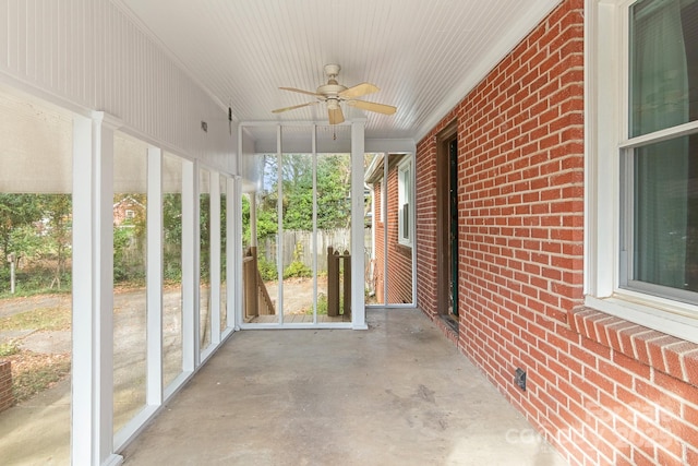 unfurnished sunroom featuring ceiling fan