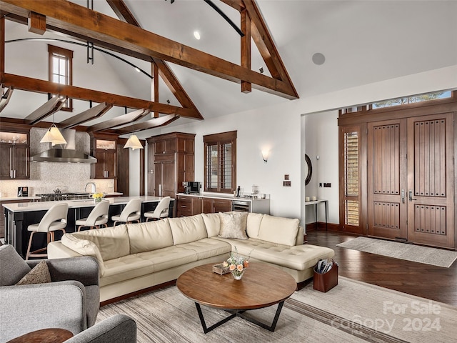 living room with light hardwood / wood-style floors, beam ceiling, and high vaulted ceiling