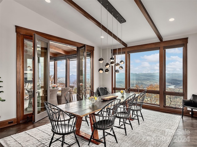 dining room with a mountain view, vaulted ceiling with beams, and dark wood-type flooring