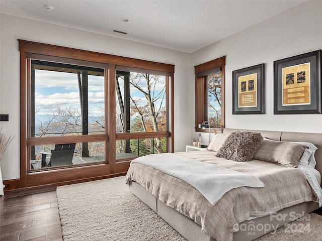 bedroom with dark hardwood / wood-style flooring