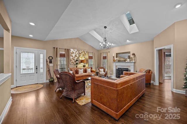 living room with vaulted ceiling with skylight, dark hardwood / wood-style flooring, and a notable chandelier