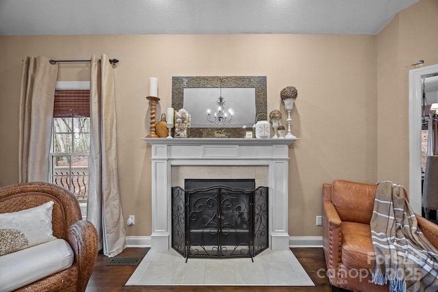 living area featuring wood-type flooring, a chandelier, and a fireplace