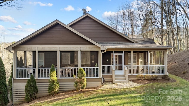 view of front of home with a front lawn and a sunroom