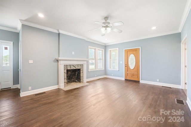 unfurnished living room with a high end fireplace, ornamental molding, dark hardwood / wood-style floors, and a healthy amount of sunlight