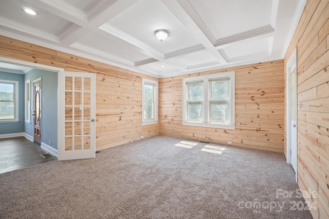 carpeted empty room with wood walls, ornamental molding, beam ceiling, and coffered ceiling