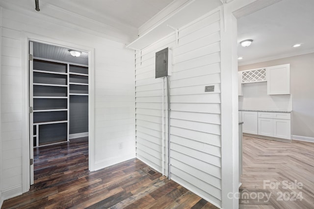 corridor featuring crown molding, electric panel, and dark hardwood / wood-style flooring