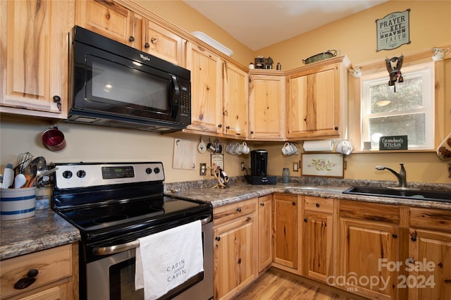 kitchen featuring dark stone counters, sink, light wood-type flooring, and electric stove