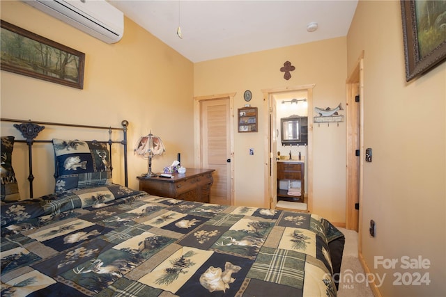 bedroom featuring connected bathroom, carpet, and an AC wall unit