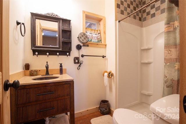 bathroom featuring toilet, vanity, and a shower with shower curtain