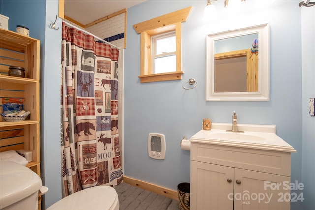 bathroom featuring toilet, hardwood / wood-style floors, heating unit, vanity, and walk in shower