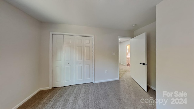 unfurnished bedroom featuring a closet and light carpet