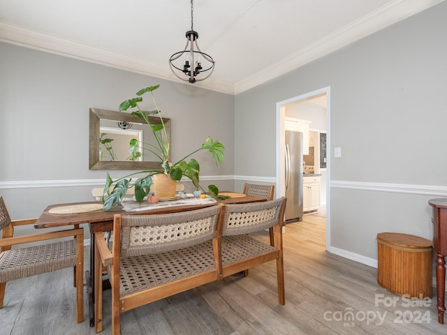 dining space with a chandelier, wood-type flooring, and crown molding