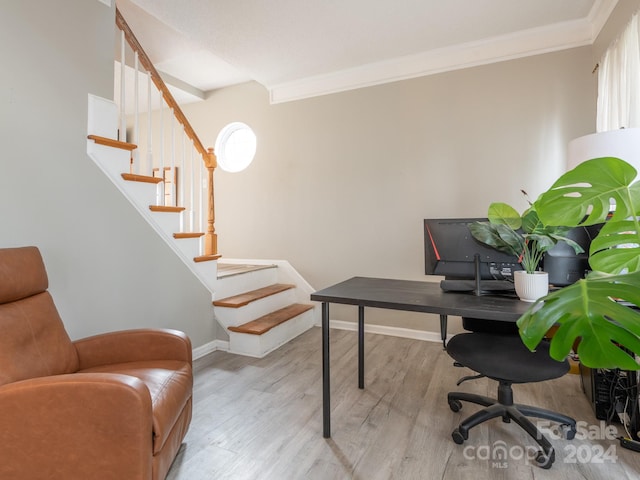 home office with light wood-type flooring and crown molding