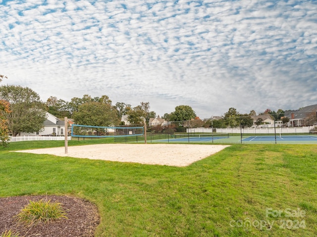 view of home's community with volleyball court, tennis court, and a lawn