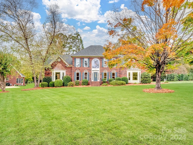 colonial-style house featuring a front yard