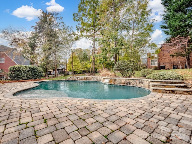 view of swimming pool featuring pool water feature and a patio area