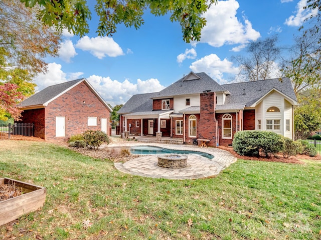 rear view of property featuring a yard, a fenced in pool, and a patio area