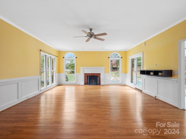 unfurnished living room featuring crown molding, plenty of natural light, and light wood-type flooring