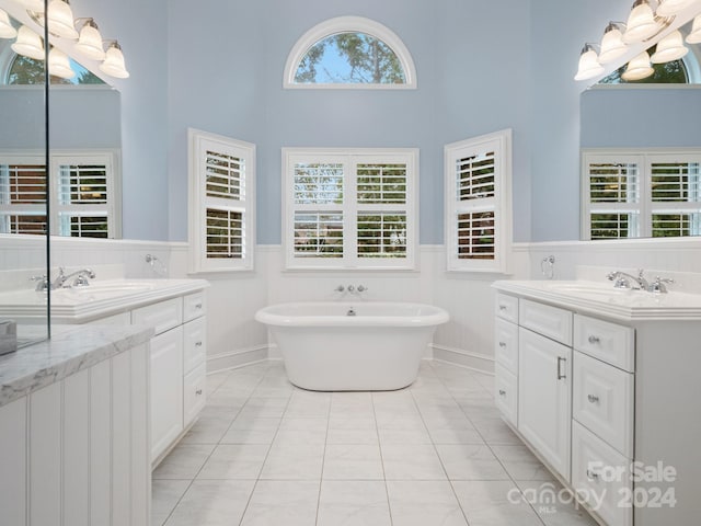 bathroom featuring a bathing tub, tile patterned flooring, a healthy amount of sunlight, and a high ceiling