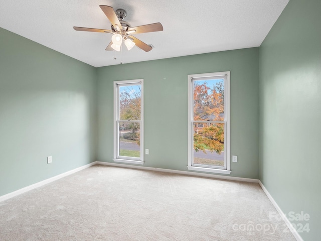 empty room with carpet, a textured ceiling, and ceiling fan