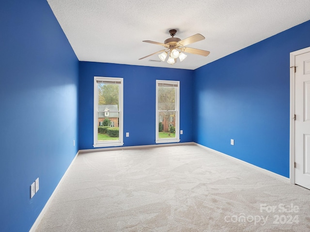 unfurnished room featuring carpet, a textured ceiling, and ceiling fan