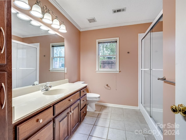 bathroom with vanity, tile patterned flooring, ornamental molding, a textured ceiling, and a shower with shower door