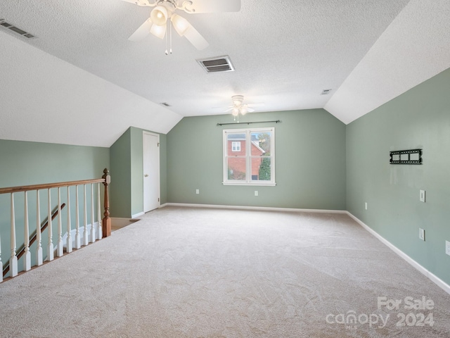 bonus room featuring a textured ceiling, ceiling fan, light carpet, and vaulted ceiling