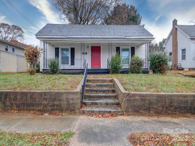 bungalow with a porch and a front lawn