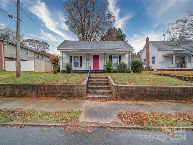 bungalow featuring a front lawn and covered porch