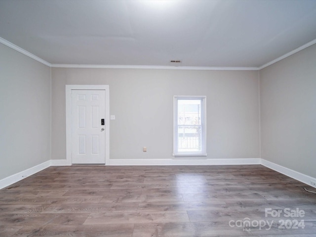 empty room featuring hardwood / wood-style flooring and ornamental molding