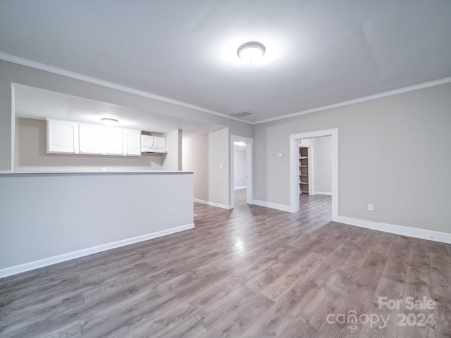 unfurnished living room with ornamental molding and light hardwood / wood-style flooring