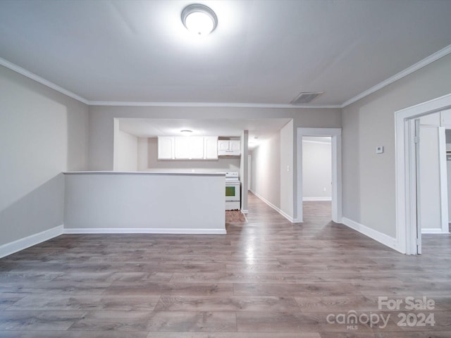 unfurnished living room featuring hardwood / wood-style flooring and crown molding