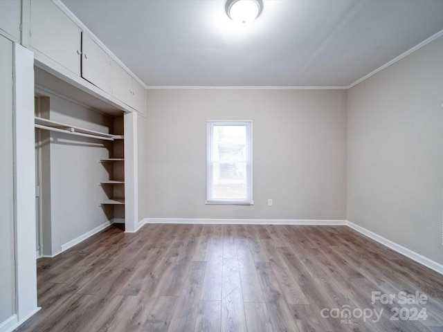 unfurnished bedroom featuring light hardwood / wood-style flooring, a closet, and ornamental molding