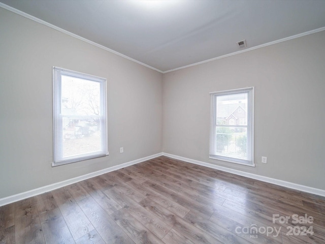 empty room featuring crown molding and hardwood / wood-style floors