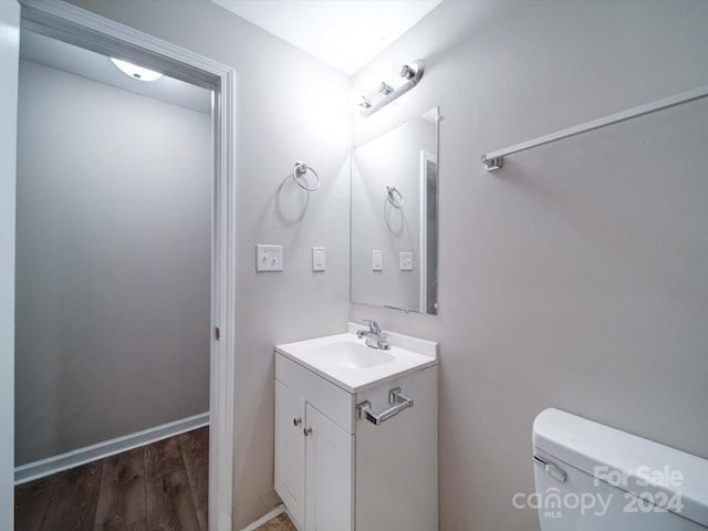 bathroom featuring wood-type flooring, vanity, and toilet