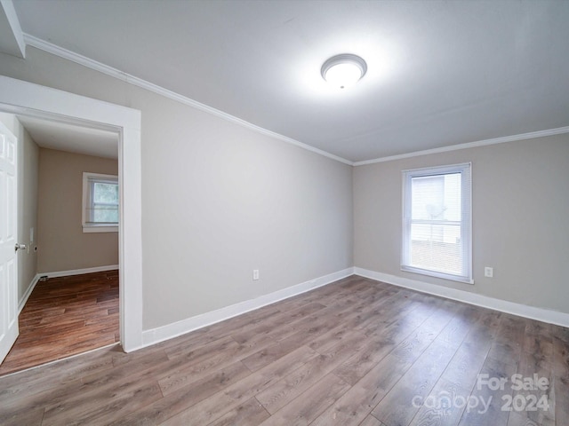 unfurnished room featuring hardwood / wood-style floors and ornamental molding