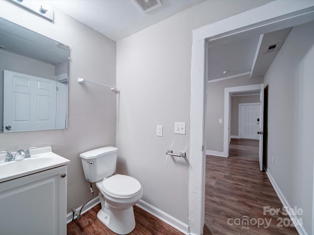 bathroom featuring hardwood / wood-style floors, vanity, vaulted ceiling, and toilet