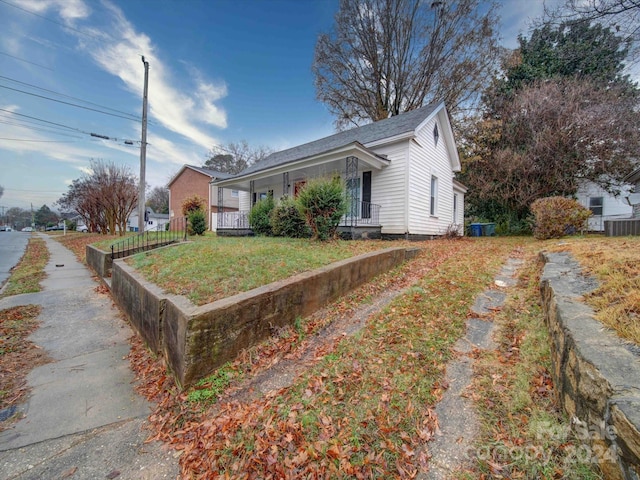 view of home's exterior with a porch and a yard