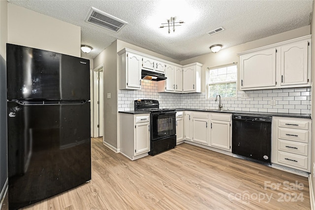 kitchen featuring black appliances, white cabinetry, decorative backsplash, and light hardwood / wood-style flooring