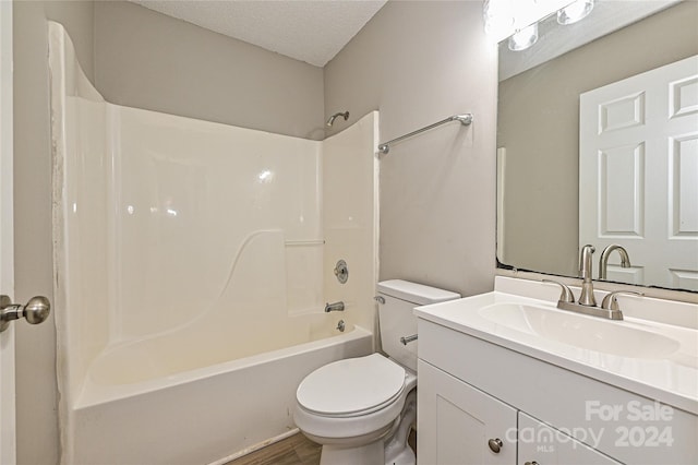 full bathroom with hardwood / wood-style flooring, a textured ceiling, vanity, bathtub / shower combination, and toilet