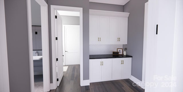 bar with white cabinets, dark hardwood / wood-style flooring, sink, and tasteful backsplash