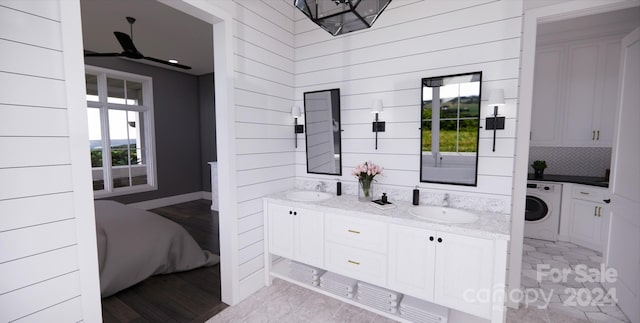 bathroom featuring wooden walls, hardwood / wood-style flooring, a healthy amount of sunlight, and washer / dryer