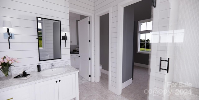 bathroom featuring toilet, vanity, wooden walls, and walk in shower