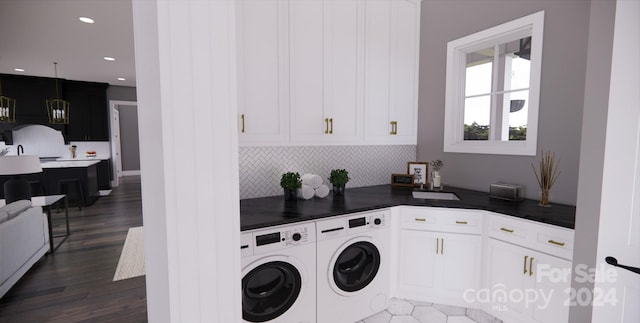 laundry area featuring cabinets, washing machine and dryer, and dark hardwood / wood-style floors